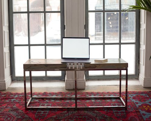 Home office desk positioned perpendicular to a large window to maximize natural light without glare