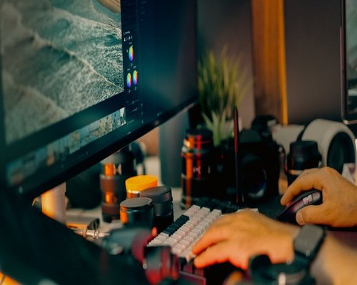Person adjusting monitor brightness in a home office setup
